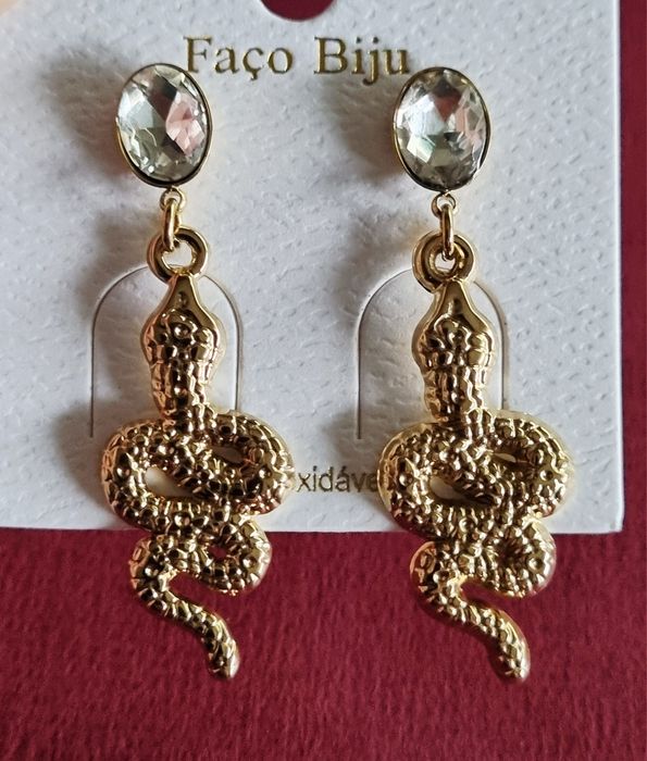 Brincos dourados, em aço, formato cobra pendurada num ponto de luz.