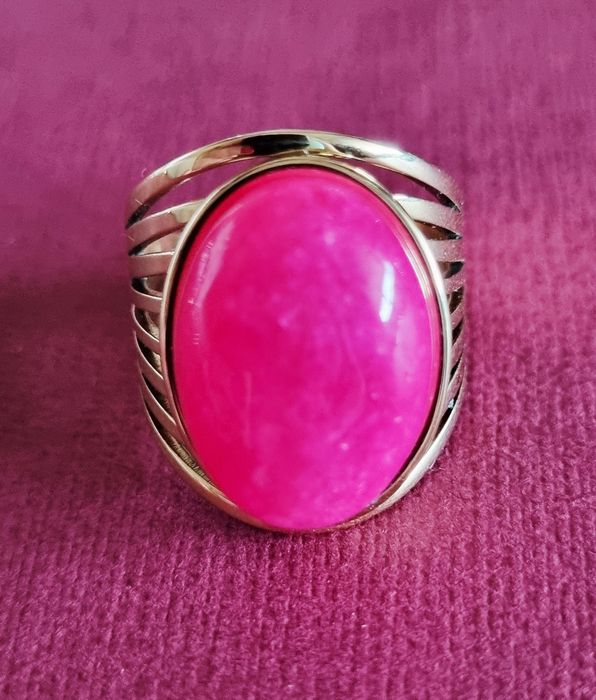Anel dourado, em aço, com pedra oval rosa fucsia. 18/ajustável