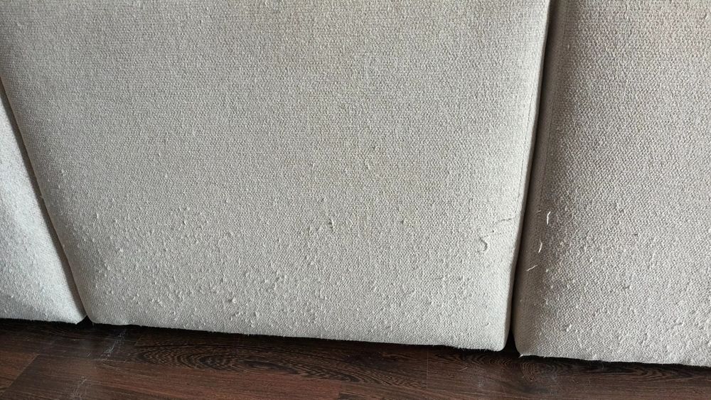 Sofá de canto bege, gato preto