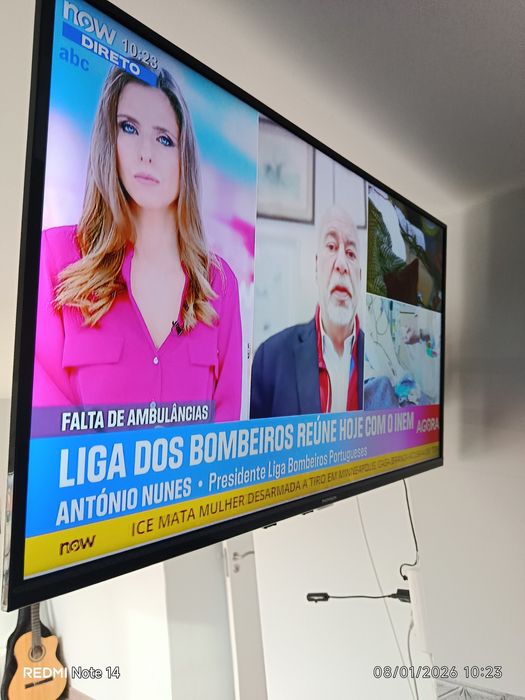 Um sofá cama, três Tvs e um refrigerador.