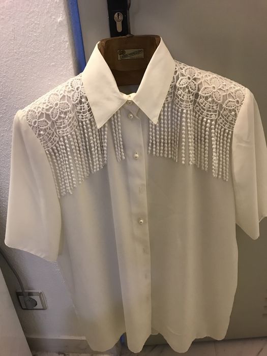 Blusa branca tipo seda com manga curta.