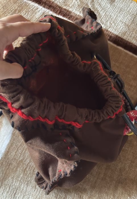 Mala de mão castanha com detalhes vermelhos