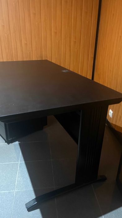 Secretária preta e modulo de gavetas.