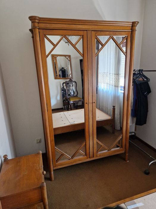 Uma cama de solteiro (2 por 1 metro) e uma mesa de cabeceira.