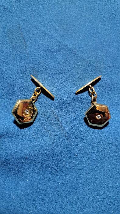 Botões de punho em prata dourada.