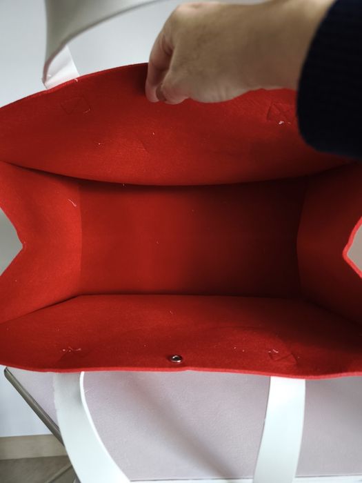 Saco de feltro encarnado com asas em pele sintética branca