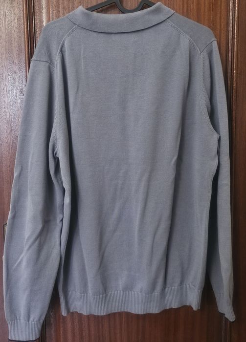 Polo de malha, de manga comprida.