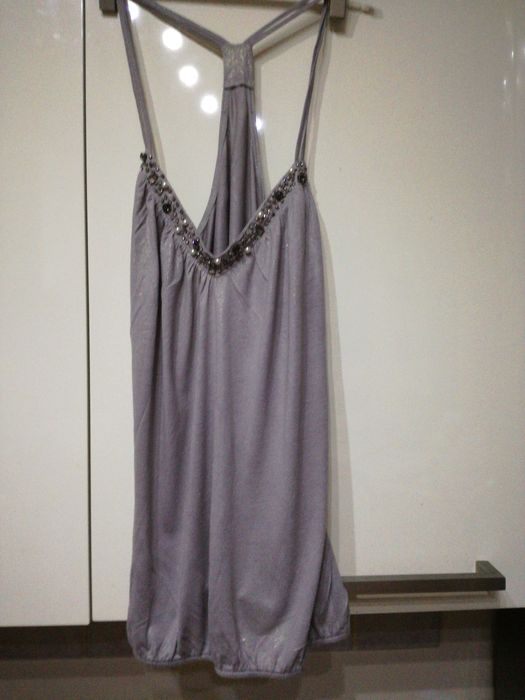 Bluzka w kolorze srebrno -szarym z biżuterią .