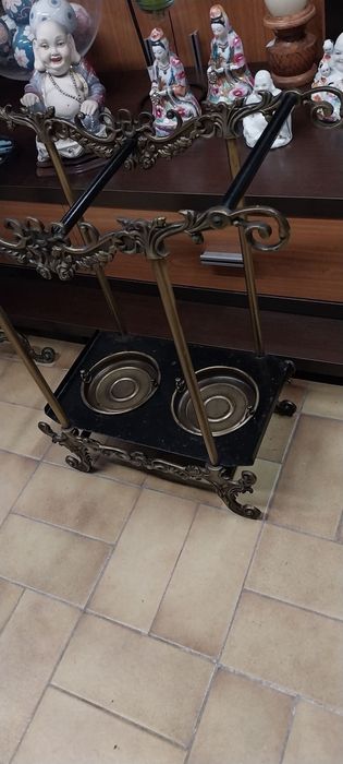 Base para guarda chuvas e espelho de parede com bengaleiro e chapeleiro. Em latão.Mesa meia lua.