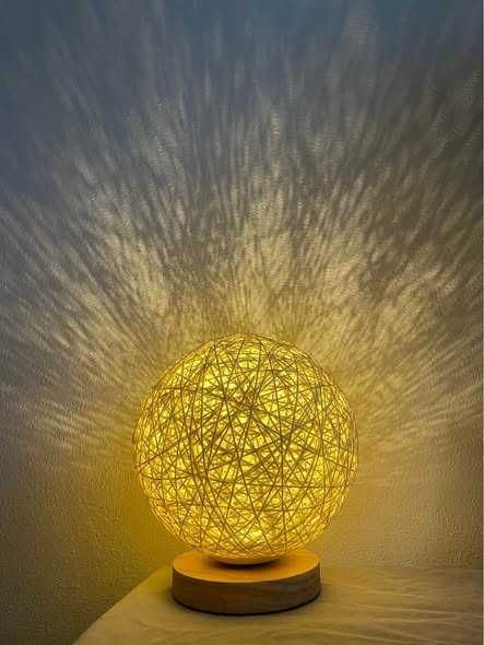 Candeeiro de mesa com esfera em fibra natural e base em madeira