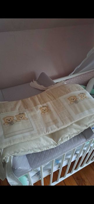 Solidne, białe łóżeczko dziecięce z baldachem.