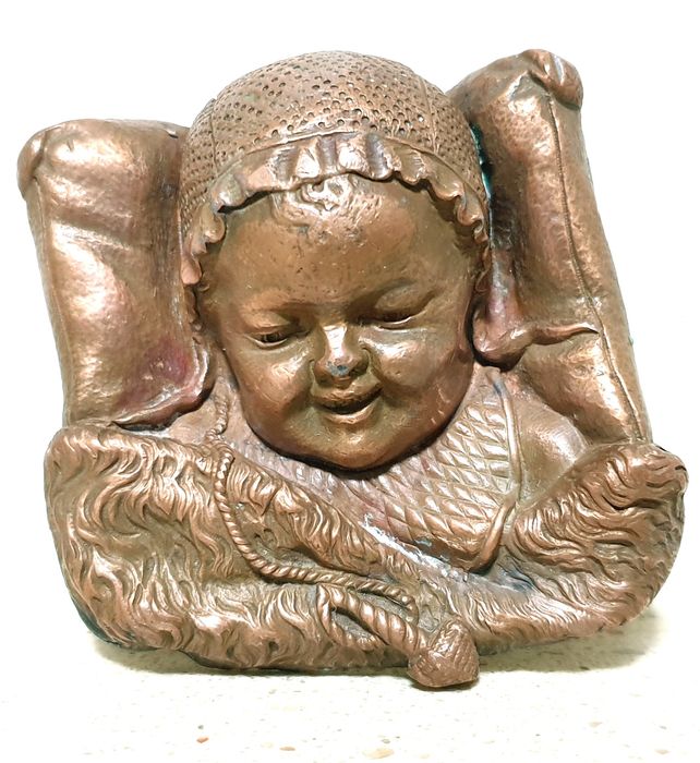 Amorosa antiga escultura de cabeça de um bebé à dormir numa almofada