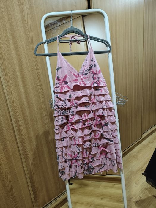 Vestido curto, com folhos cor de rosa.