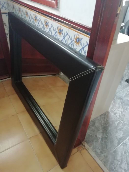 Espelho com moldura em pele.