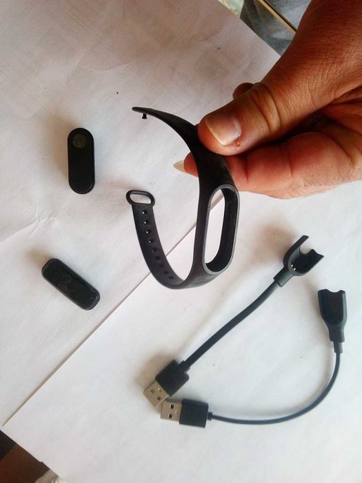 Relógios esportivos inteligentes fitness, pulseira e carregadores.
