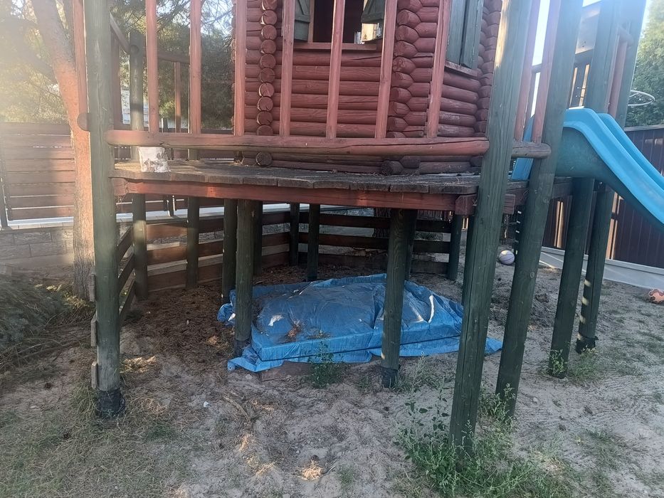 Domek dla dzieci, z zjeżdżalnią i piaskownicą.