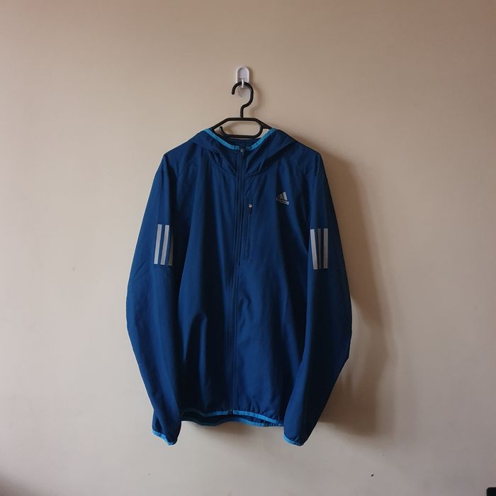 Adidas kurtka own the run hooded wind jacket do biegania niebieskia