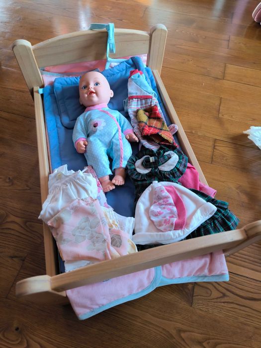 Caminha de bonecas com boneco e roupinhas do mesmo.