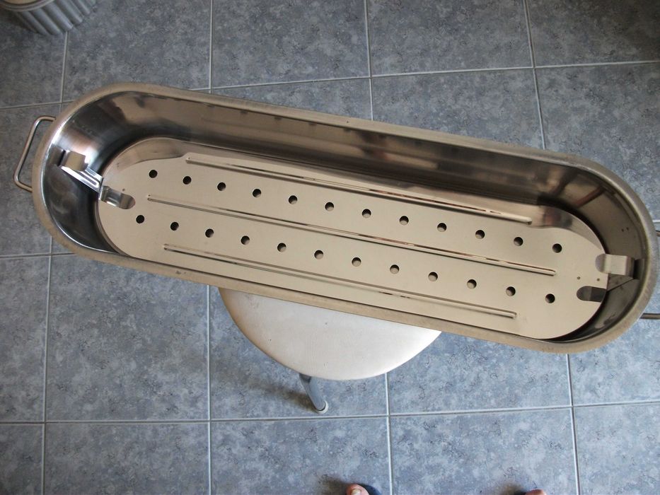Tacho em aço inox próprio para cozer peixe inteiro.
