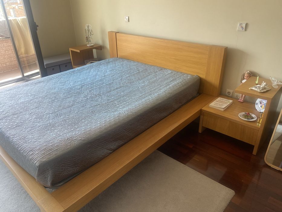 Quarto com cama de casal, colchao e mesinhas de cabeceira