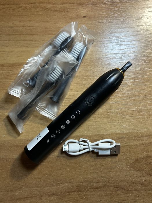 Нова електрична забна щітка чорного кольору зі змінними насадками