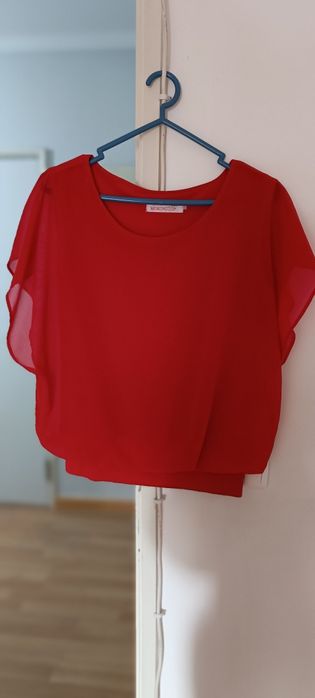 Camisola vermelha aberta de lado usada. Não tem etiqueta, mas veste M.