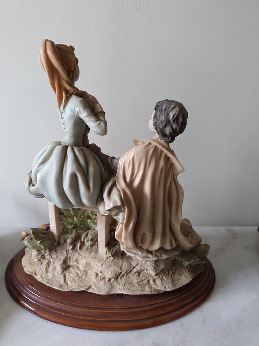 Estátua de dois amantes em base de madeira