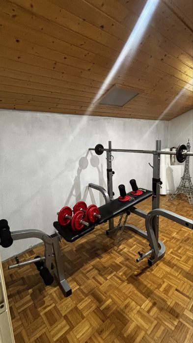 Banco de musculação com suporte para barra + halteres.