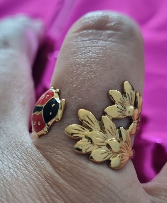 Anel dourado, em aço, com folhas e 1 joaninha. Ajustável