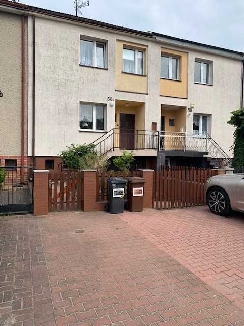 Jednopiętrowy dom w zabudowie szeregowej ,  z garażem , z ogrodem.