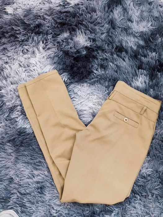Жіночі брюки гірчичного кольору.