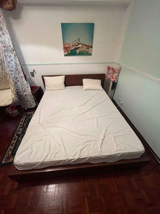 Cama de casal com mesa de cabeceira e apoio