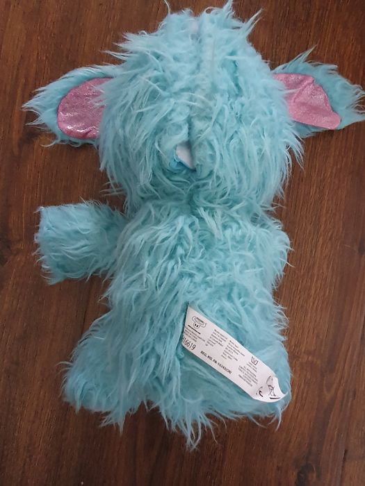 Pies piesek niebiesko biały z długą sierścią wydaje dźwięk szczekania