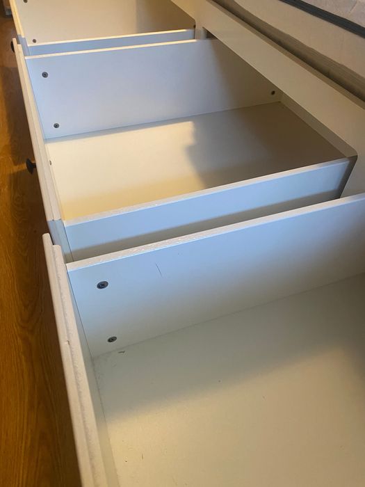 Um sofá, uma cama individual, uma cama de casal e arrumação