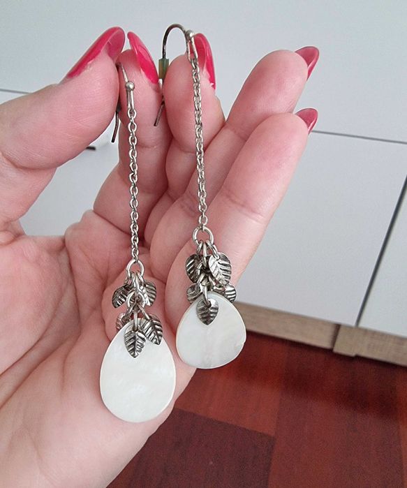 Brincos brancos e prateados com detalhes de folhas