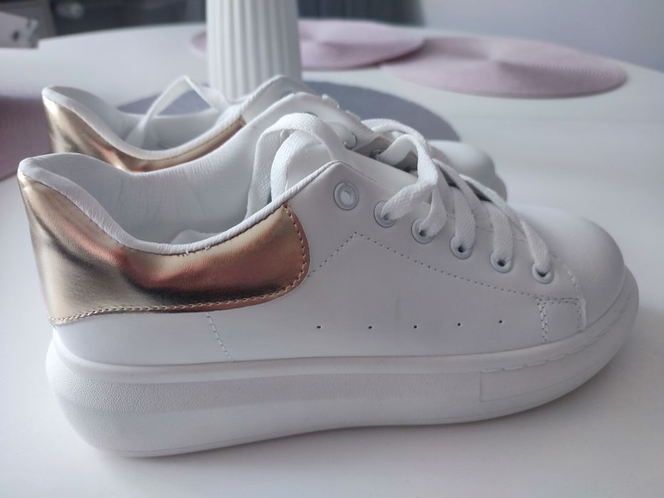 Białe sneakersy ze złotym wykończeniem