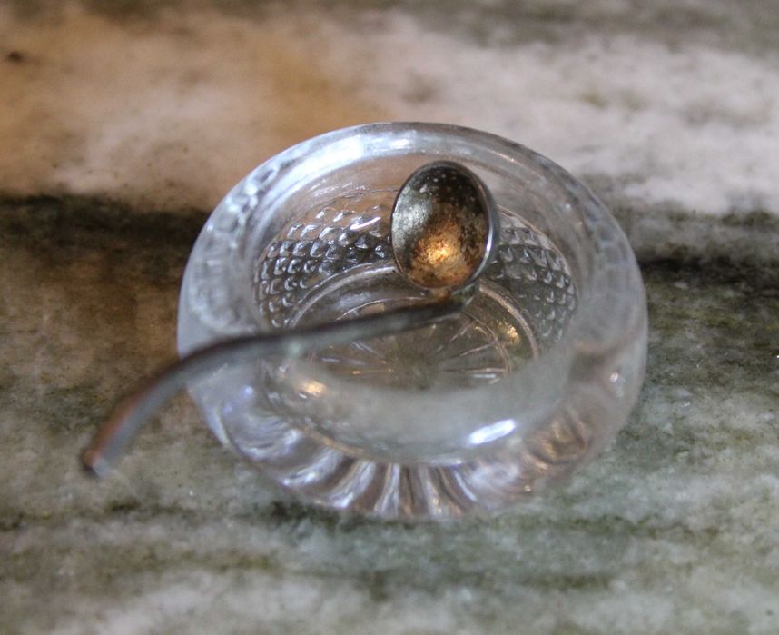 Saleiro de cristal com prato e pequena colher em casquinha, marcado.