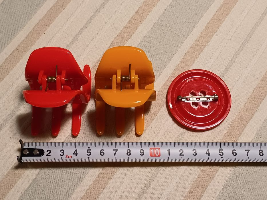 2 ganchos de cabelo (vermelho e laranja) + broche botão vermelho

Como