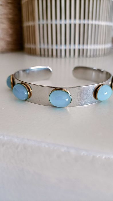 Pulseira em aço prateado e pedras azuis.