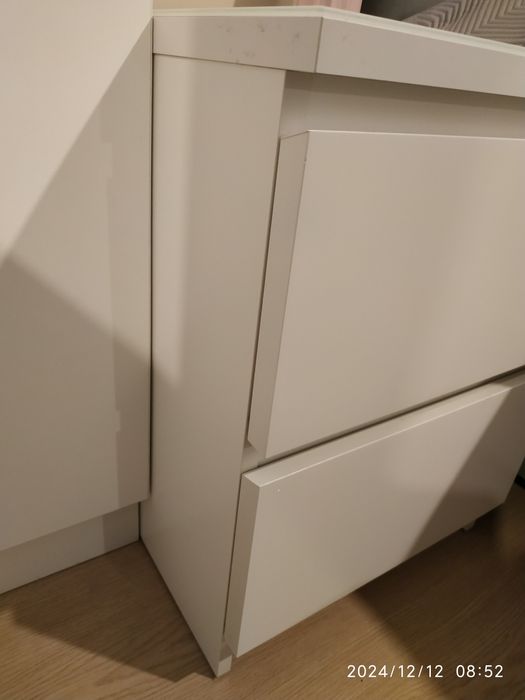 Dwie białe szafki nocne Malm wraz z białym szkłem ochronnym.