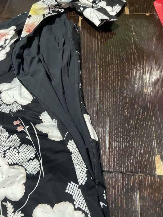 Vestido modelo Oasis Belle uma peça de cocktail com decote de um só onbro e padrão floral sobre fundo preto
