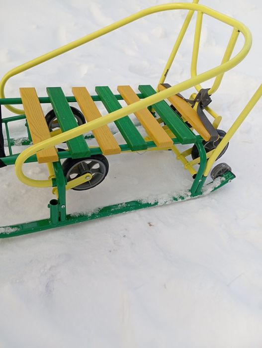 Дитячі санчата на колесах з капішоном.