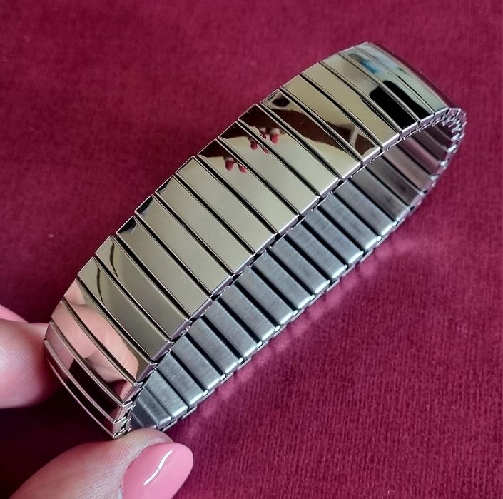 Pulseira elástica prateada, em aço inoxidável.