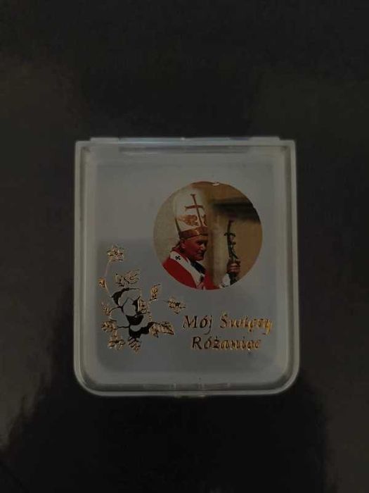 Różaniec komunijny z czarnymi perłami i pudełkiem z Janem Pawłem II.