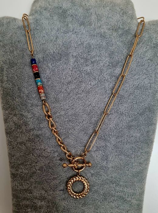 Colar dourado, em aço, assimétrico e com pedrinhas naturais coloridas.