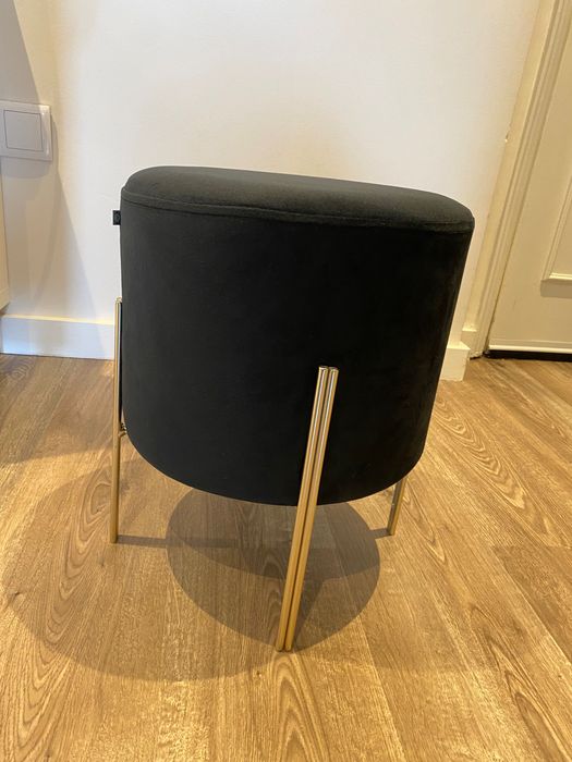 Puff preto com pernas em metal dourado, dimensões 40x34 cm