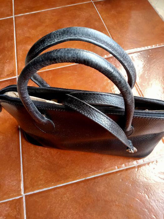 Mala em pele de mão e a tiracolo