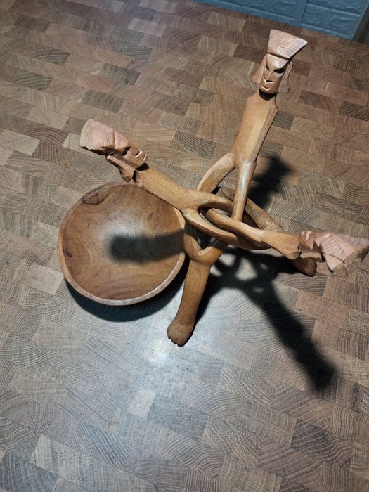 Taça de madeira com suporte de caras talhadas na madeira