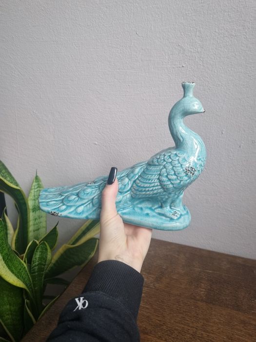 ceramiczna figurka pawia w kolorze turkusowym.