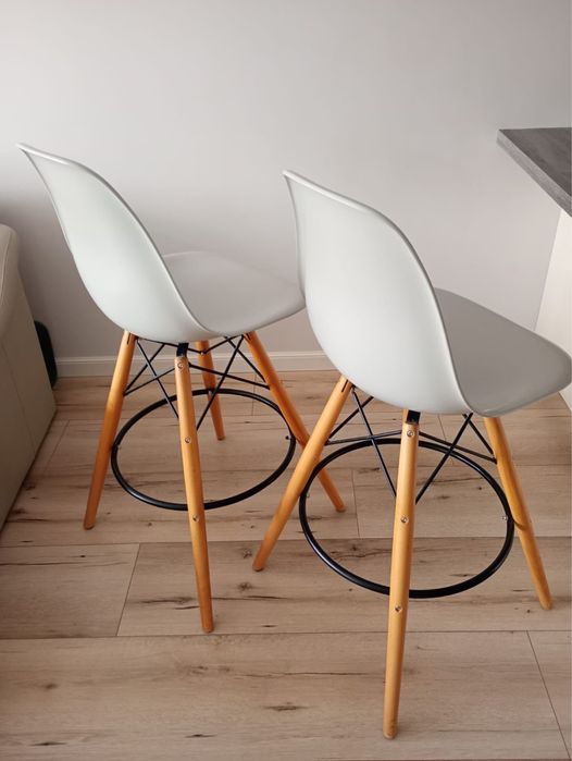 Krzeslo hoker w stylu Eames z szarym siedziskiem i drewnianymi nogami